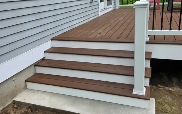 Composite deck stair treads with white risers on a concrete landing